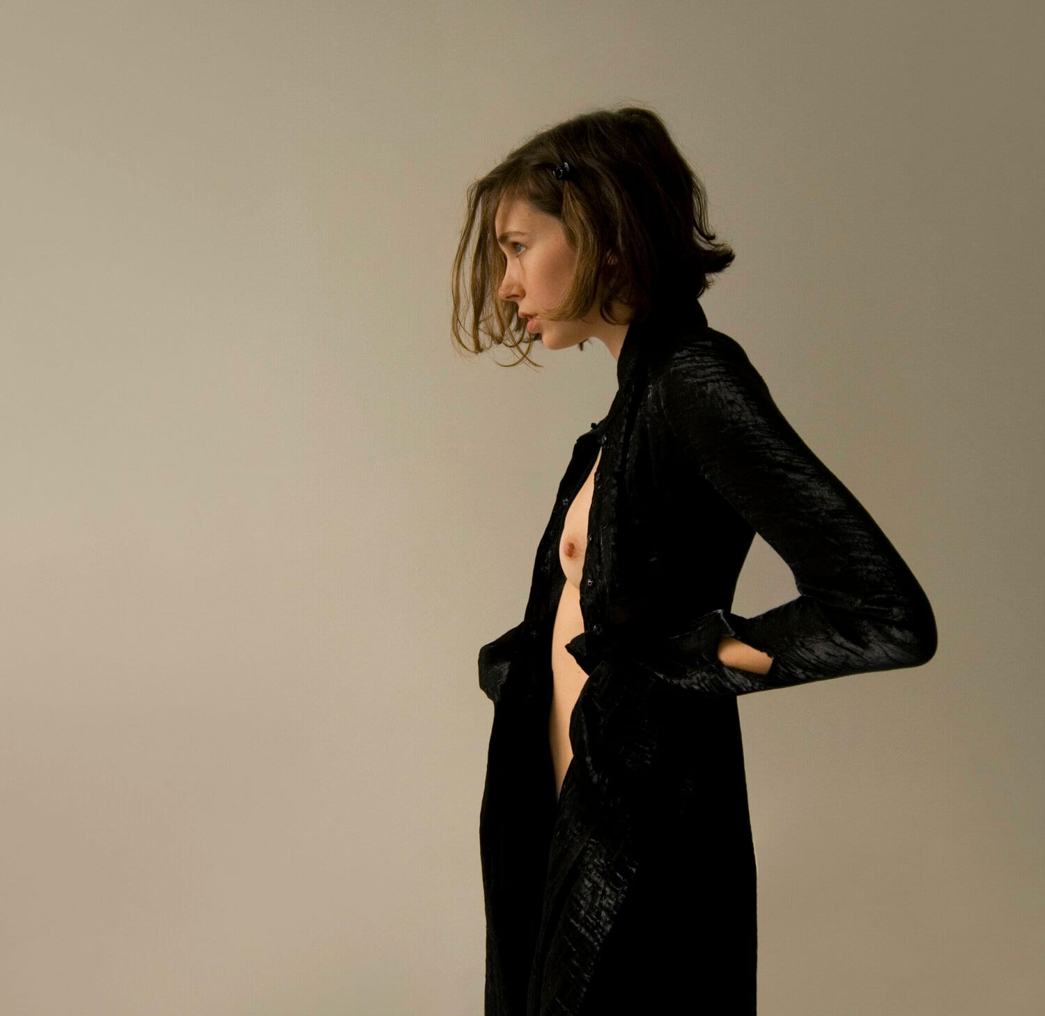 A woman in a black coat in profile against a grey wall. afactum, 2010, Digital print on metal, Alu-Dibond, 50 x 50 cm